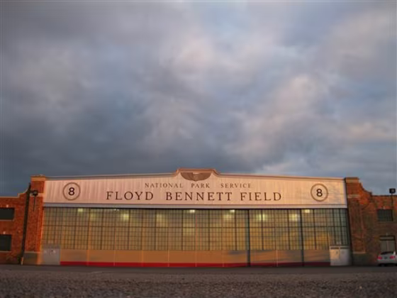 A&nbsp;National Park Service hangar emblazoned with the name Floyd Bennett Field glows orange at sunset March 11 at New York City's "ghost airport" in Brooklyn, N.Y. 